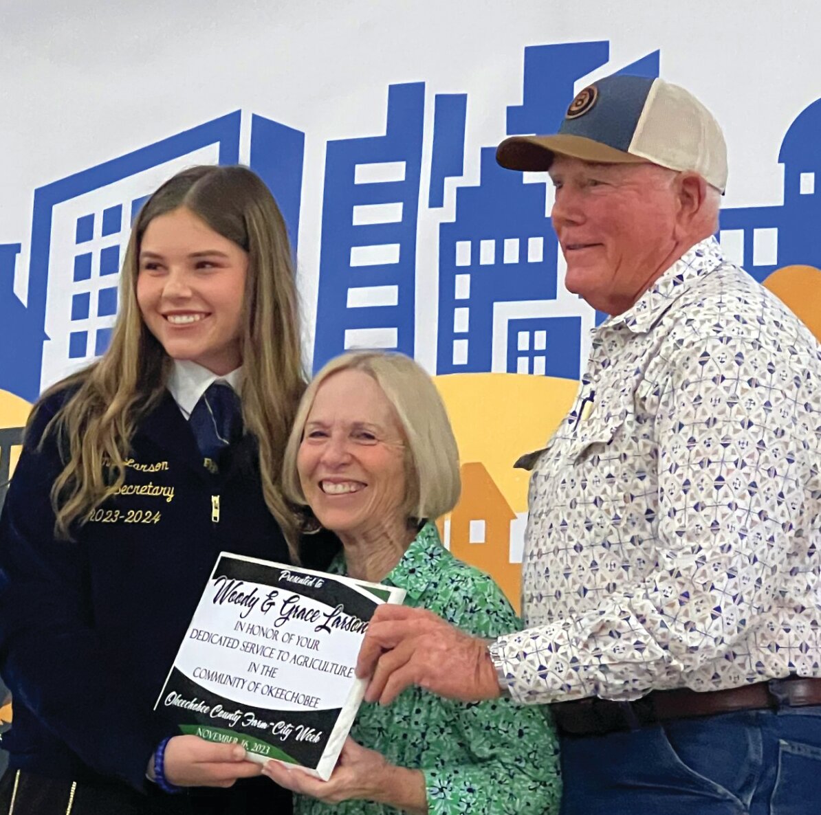 OKEECHOBEE -- Florida FFA State Secretary Jenna Larson (left) presented Grace and Woody Larson with the award for Dedicated Service to Agriculture in the Community of Okeechobee at the Nov. 16 Farm City Week Luncheon at the Okeechobee County Agri-Civic Center.